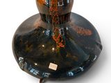 a vase that is sitting on a stand on a white surface