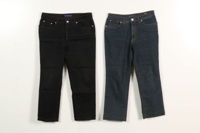 two pairs of jeans hanging on a wall next to each other