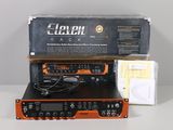 une radio orange et noire posée sur une table, à côté d'une boîte