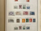 an open book with stamps on it on a table