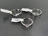 three silver rings with tags on them sitting on a table