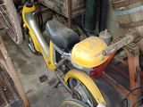 a yellow bike parked in a garage with a basket on the back