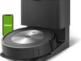 a close up of a robot vacuum with a phone in front of it
