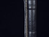 a close up of a black leather book with gold trim