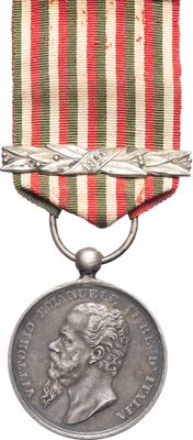 an old medal with a red, white, and green ribbon around it