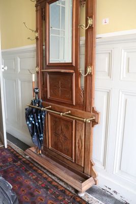 une horloge de parquet en bois avec un parapluie posé sur un tapis