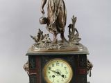 a statue of a woman holding a bird and a clock