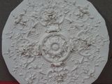 a white plate with a design on it sitting on a red cloth