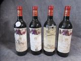 quatre bouteilles de vin sont alignées sur une surface grise