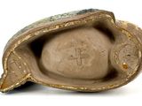 a close up of a clay object with a cross on it