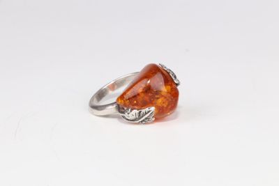 une bague en argent ornée d'une pierre orange et de feuilles