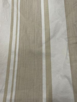 beige and white striped fabric on a bed with a white pillow