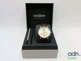 l'image d'une montre dans une boîte sur une surface blanche
