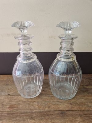 two clear glass bottles sitting on a wooden table