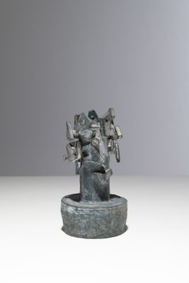 statue d'un homme avec un oiseau sur l'épaule, posée sur un socle