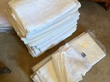 une pile de serviettes pliées posée par terre à côté d'une commode