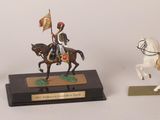 three figurines of a man on a horse and a man on a horse