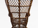 wicker chair with curved seat and foot rest