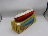 un bateau rouge et blanc posé sur une boîte jaune