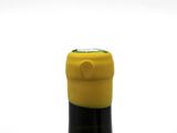 a bottle of wine that has a yellow cap on it