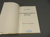 un livre ouvert, à la couverture blanche, posé sur une table