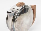 stainless steel teapot with wooden stand on a white background
