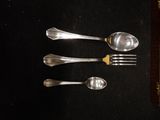 four silver spoons and two silver spoons on a table