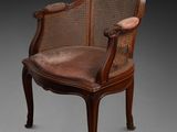 une vieille chaise avec un dossier en rotin et une assise marron