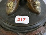 a bronze statue of a pair of shoes on a pedestal