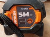 an orange and black measuring tape sitting on top of a wooden table