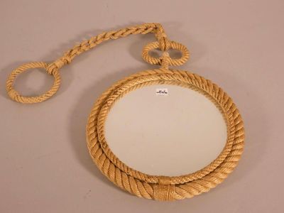 a mirror with a rope around it on a table