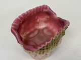 a pink and green bowl with a baby in it