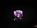 une bague en améthyste ornée d'une pierre violette sur un fond noir