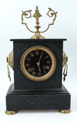 a black and gold clock sitting on top of a table