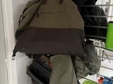 many bags hanging on a rack in a room