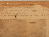 an old piece of paper with writing on it sitting on top of a table