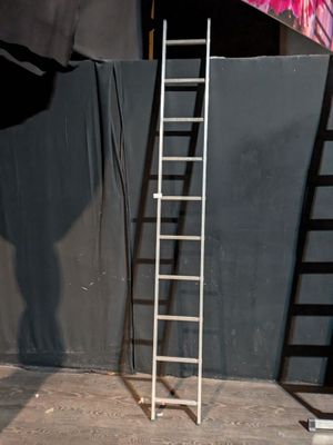 a ladder leaning up against a wall with a painting on it