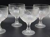 six verres à vin transparents posés sur une table noire