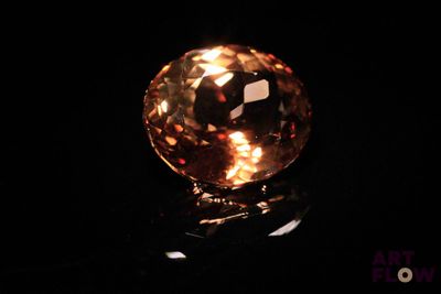 a close up of a yellow diamond on a black surface