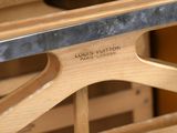 a close up of a wooden bench with a louis vuitton label on it