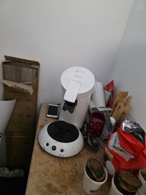 une cafetière posée sur un plan de travail dans un coin de la pièce