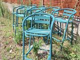 many chairs that are sitting in the grass by the fence
