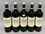 six bottles of wine are lined up in a row on a table