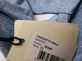a label on a blue shirt that is attached to a pair of jeans