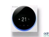 un thermostat intelligent blanc et bleu posé sur un boîtier blanc