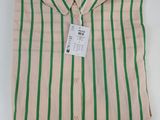 une chemise rayée verte et blanche avec une étiquette dessus