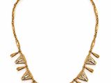 a gold necklace with spikes on a gold chain