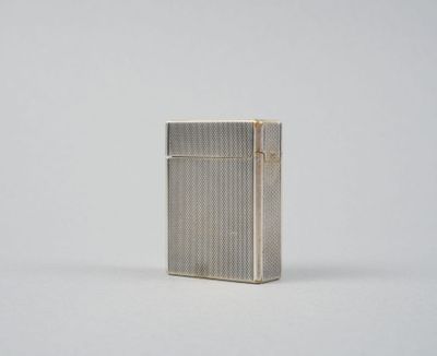 un briquet argenté posé sur une surface blanche