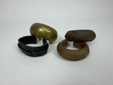 three pieces of wood and brass bracelets on a white surface