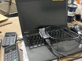 a laptop computer sitting on top of a desk with remotes